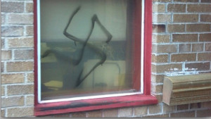 A swastika spray-painted onto a window, similar to the one spray painted in a Jewish fraternity at Penn State last year.